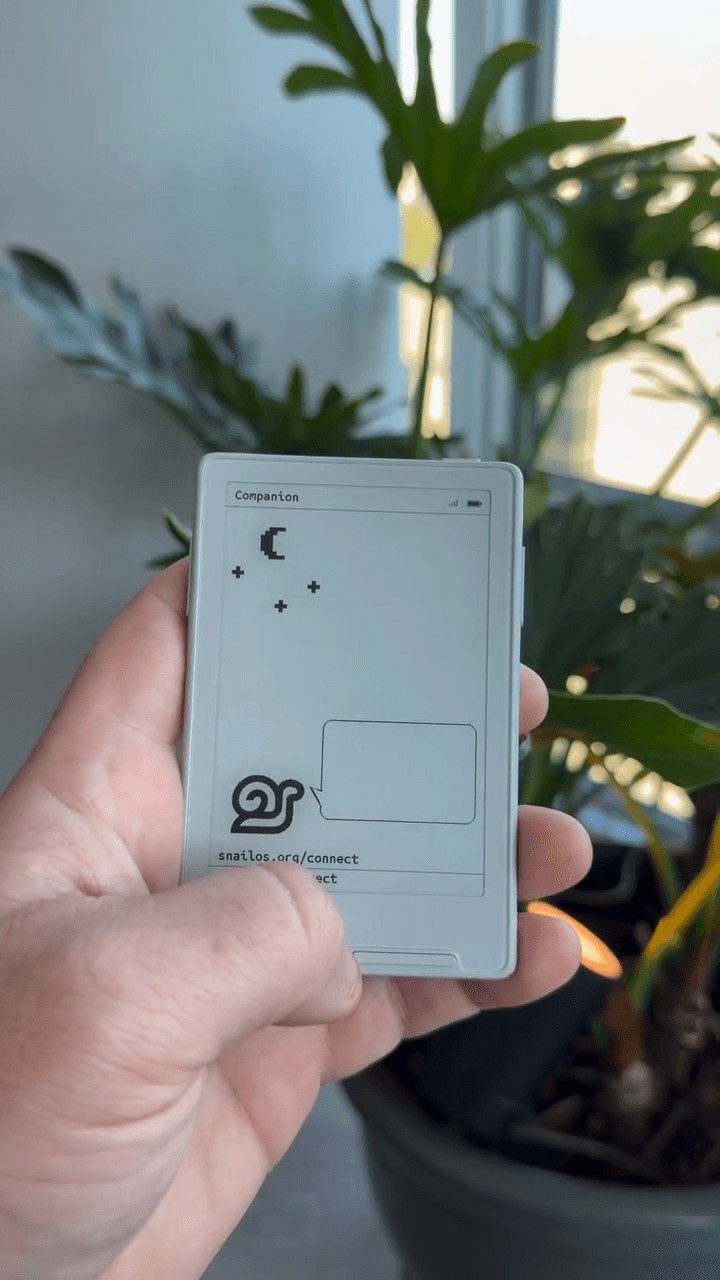 Snail Companion prototype, held in a hand.