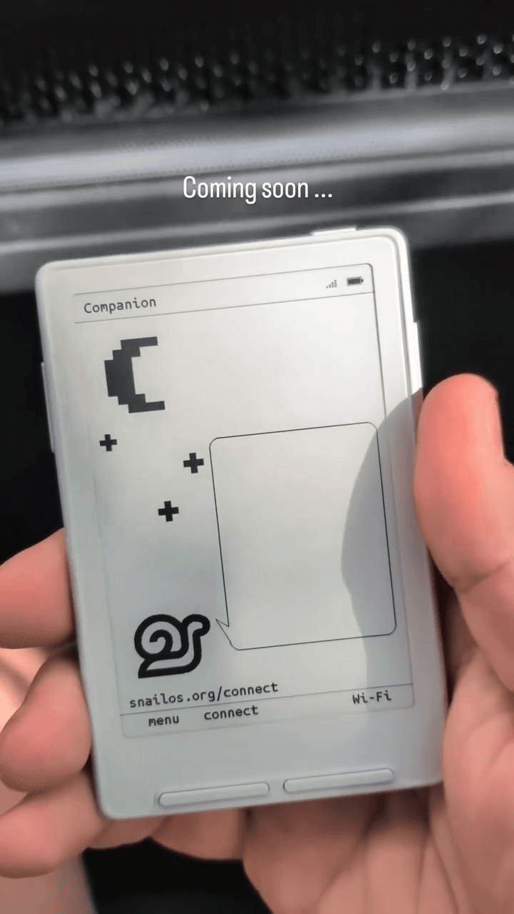 Snail OS on XTEINK, held in a hand.